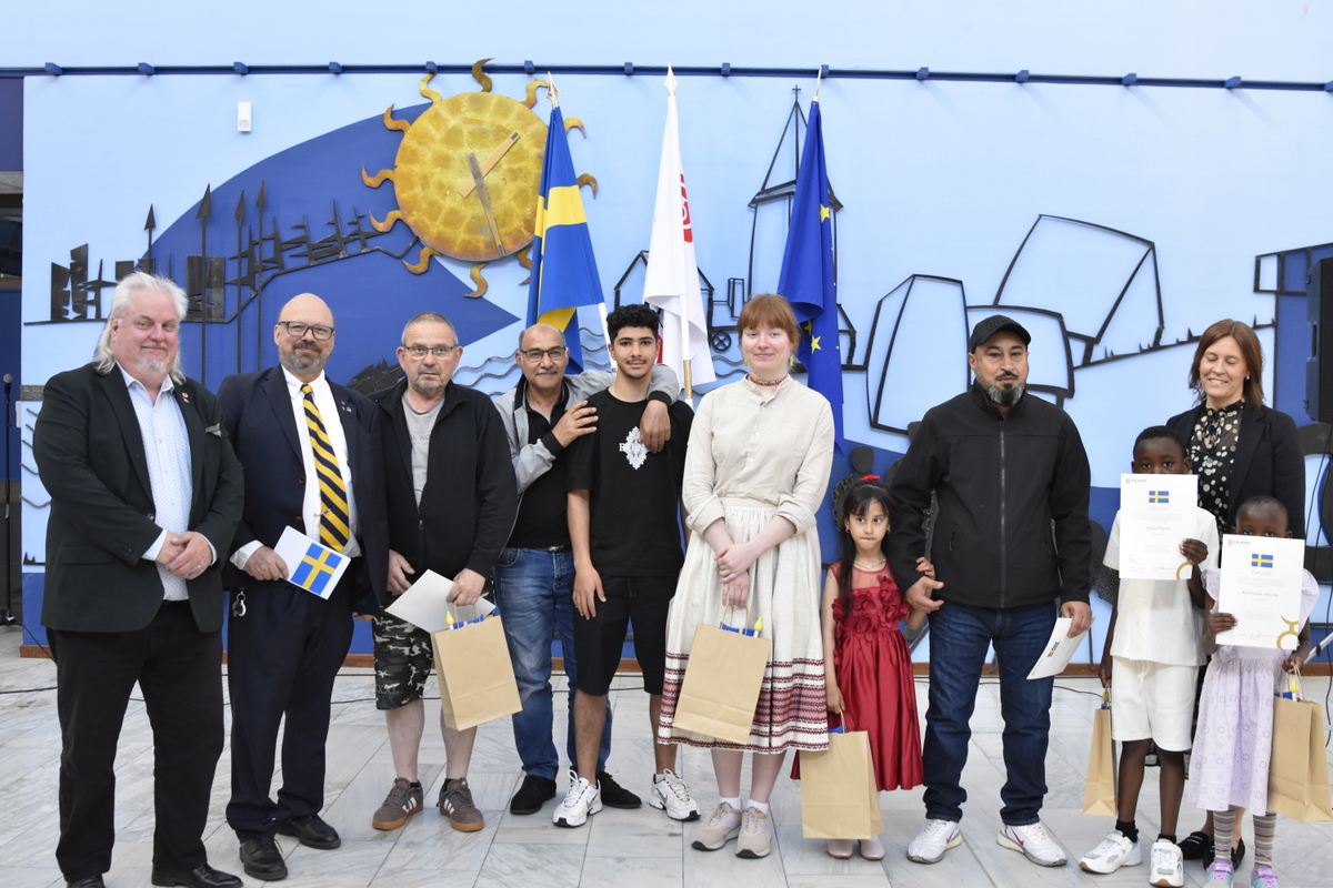 gruppbild på nya svenska medborgare tillsammans med fullmäktiges presidium.