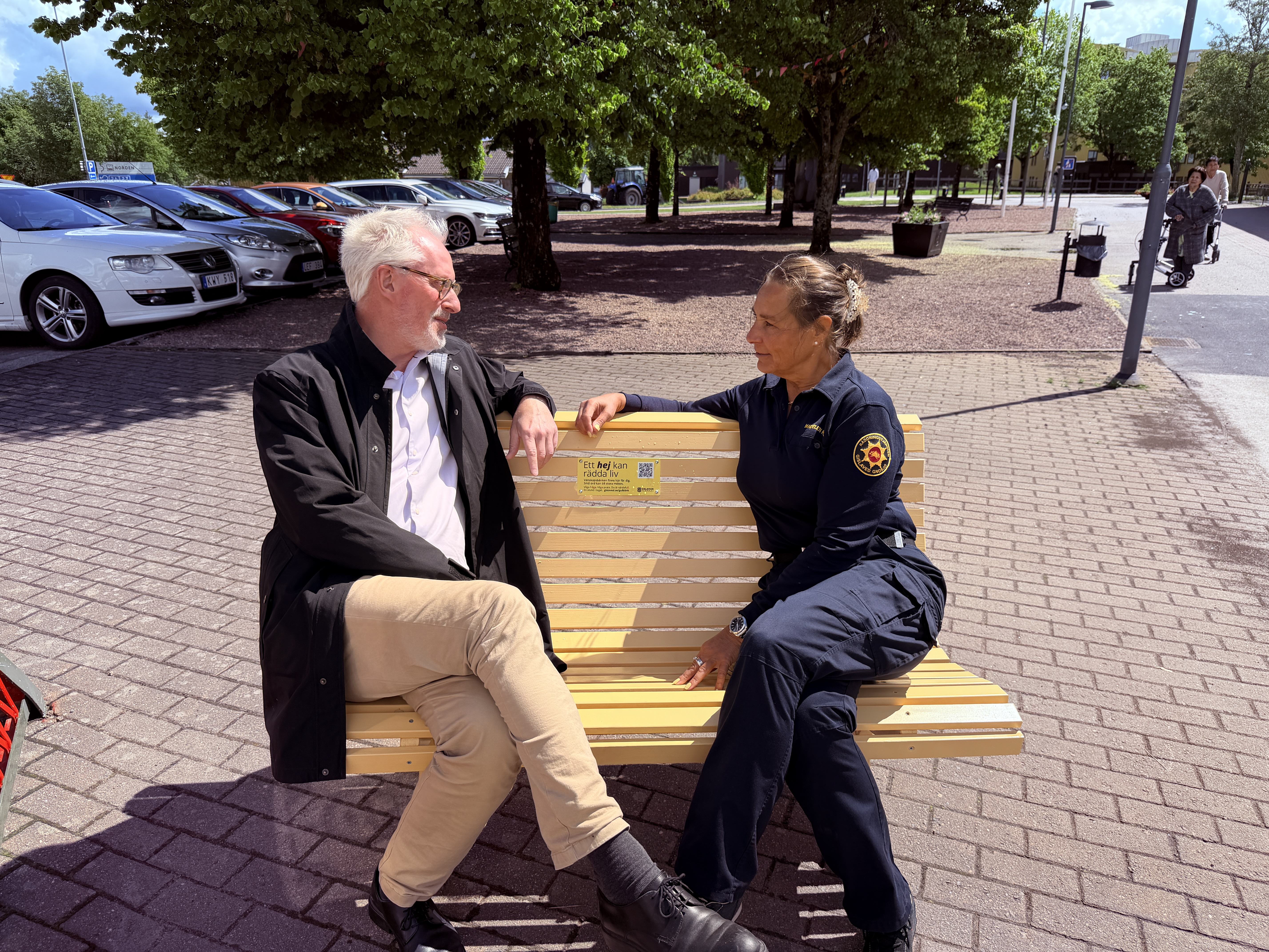 Stefan Eglinger och Madelen Kjell på en gul bänk i Gislaved.