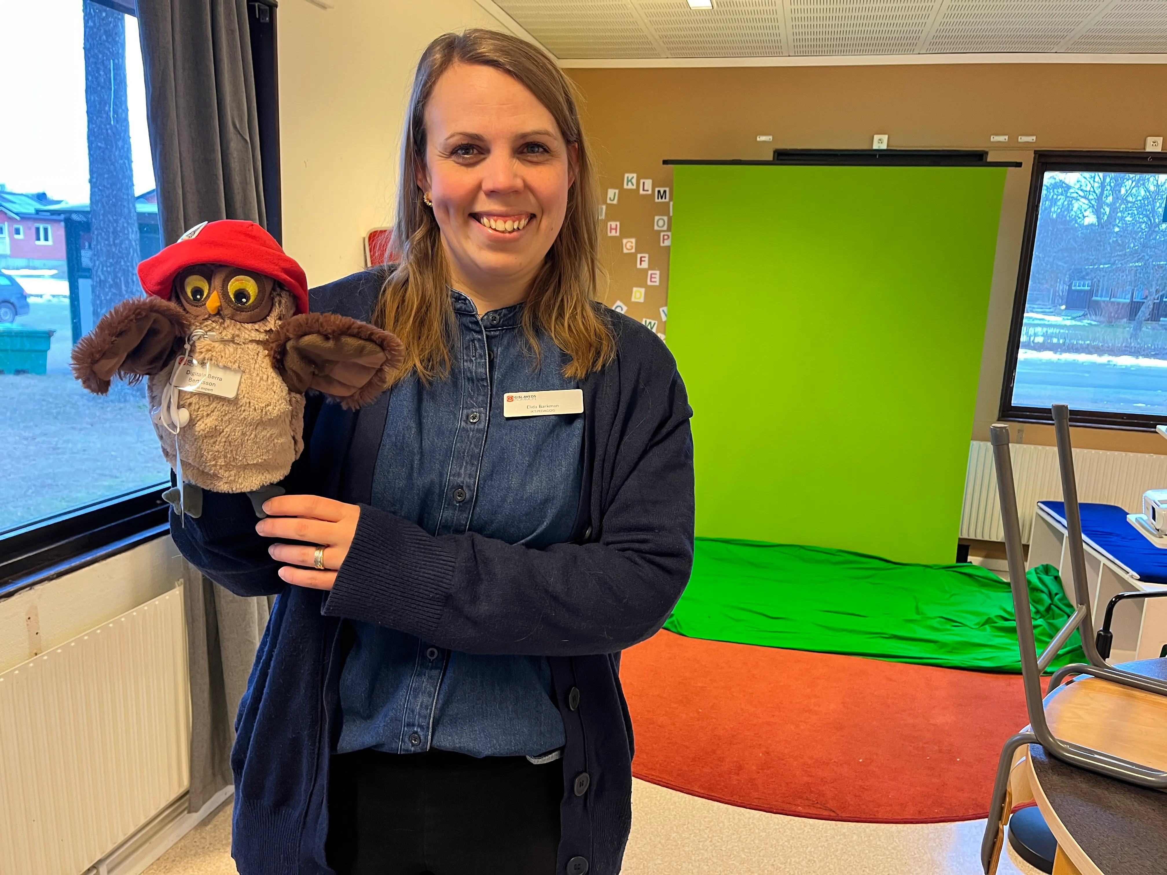 Foto på en kvinna som håller i en handdocka, handdockan är en uggla.