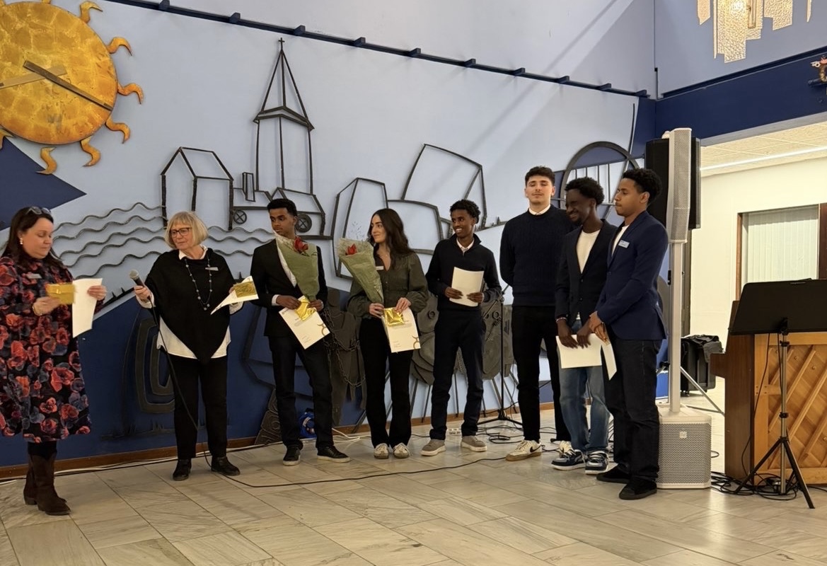 Foto på medlemmar ur ungdomsrådet stående inne i kommunhuset i ljushallen.