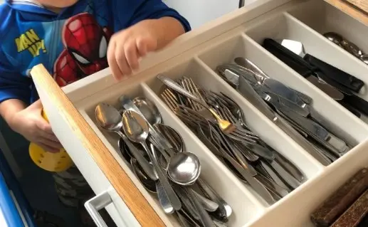 Ett foto på en öppen kökslåda med bestick i som är sorterade.