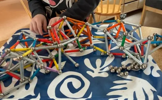 Foto på magnetiska stavar som ett barn byggt ett torn med.
