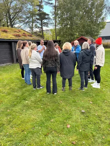 Foto på folk som står och pratar i en ring.