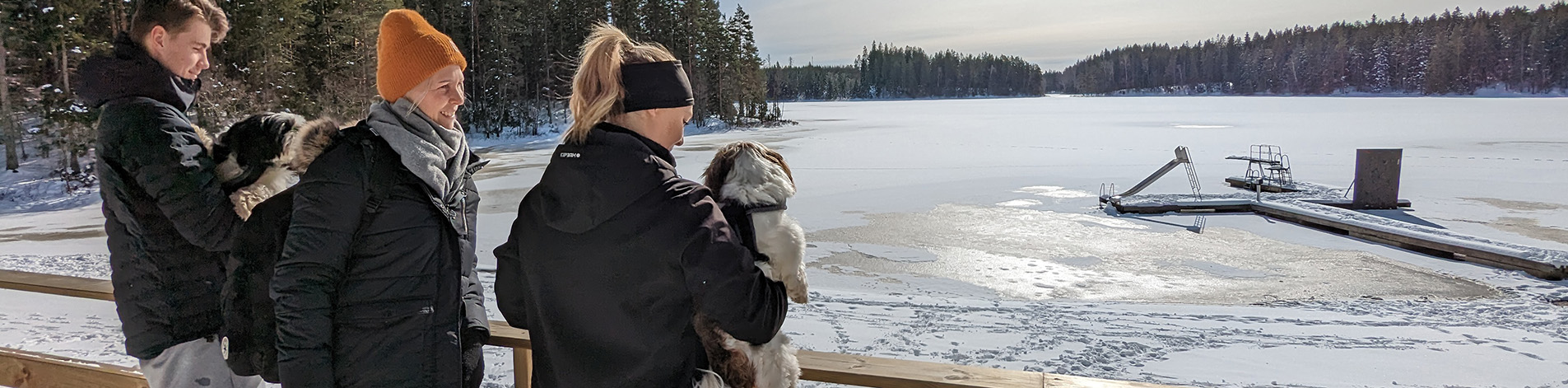 tre personer blickar ut över Gussjön som är isbelagd.