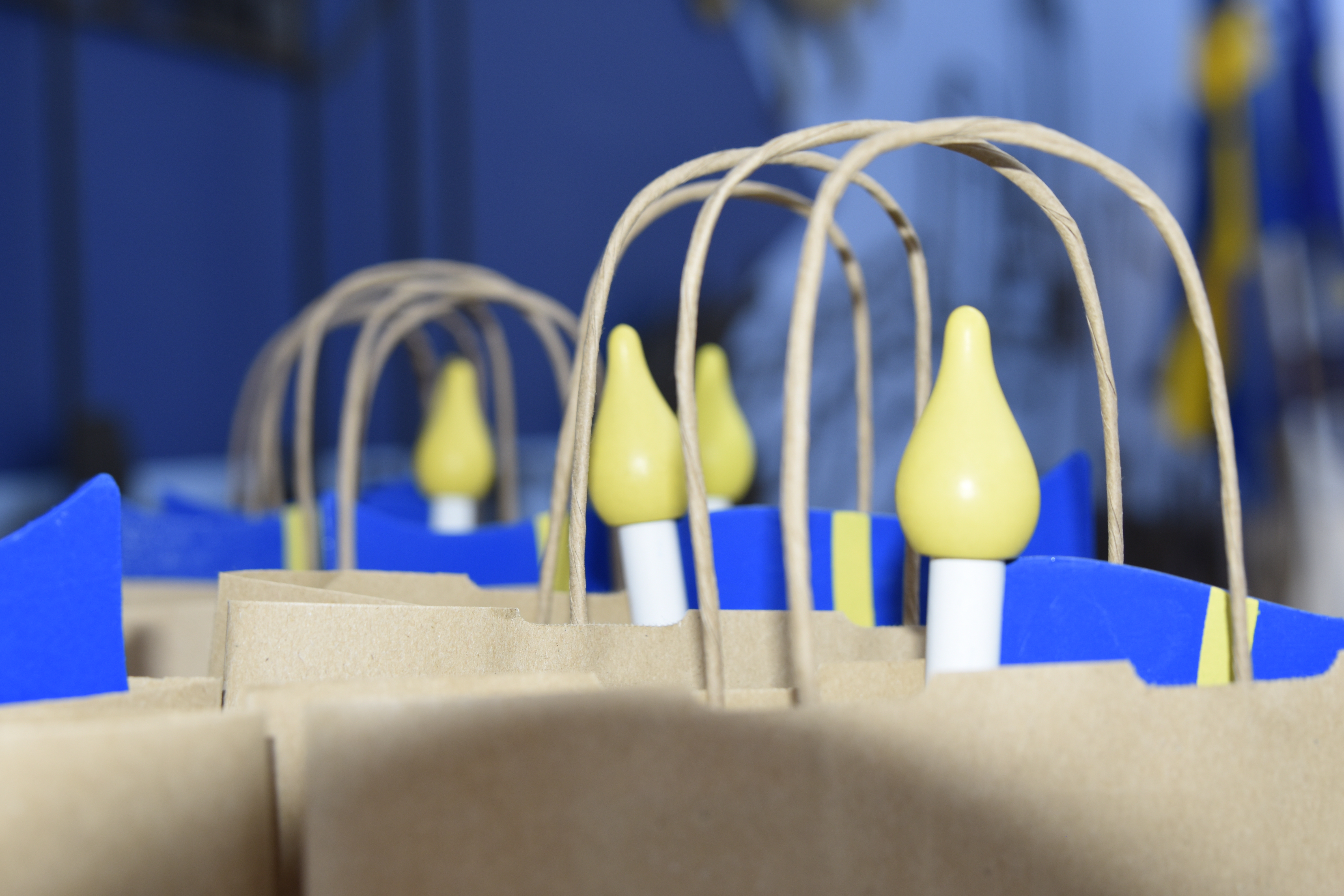 Bordsflaggor med svenska flaggan som sticker upp ur papperskassar.