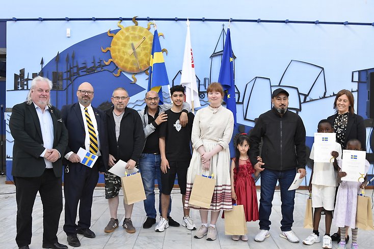 gruppbild på nya svenska medborgare tillsammans med fullmäktiges presidium.