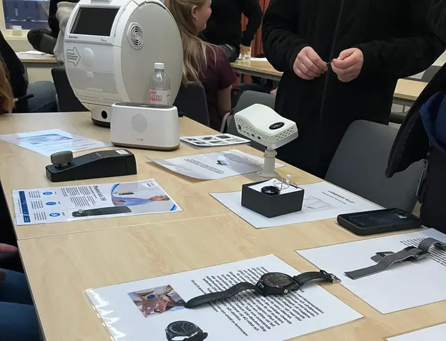 Bild på ett bord. På bordet finns trygghetslarm i form av klockor, det finns också en medicinrobot och andra tekniska apparater som används inom äldreomsorgen.