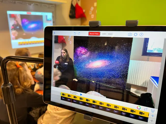 Foto på förberedelser inför ett pass med digitala Berra, gröna skärmar och en ipad som visar rymden.