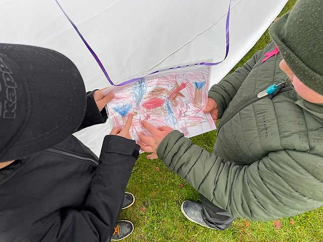 Två barn pekar på en teckning.