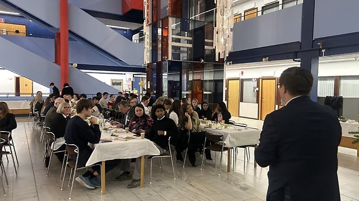 Foto taget inne i kommunhuset, folk sitter ned vid bord och lyssnar till en talare.