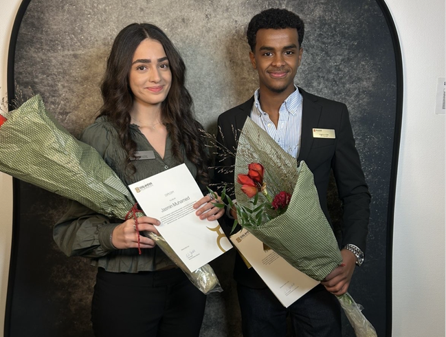 Foto på en ung kvinna och en ung man, med varsin blombukett och diplom.