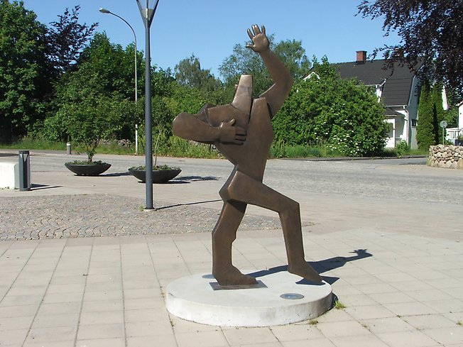 en skulptur som dansar på ett asfalterat torg