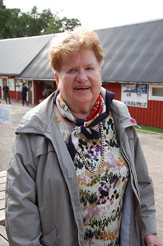 Anita, pensionär, skrattar utanför ingången till restaurangen Tiraholm.