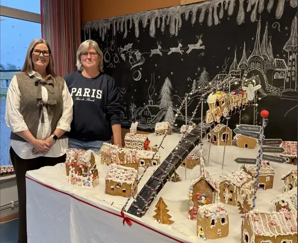 Foto på Helena och Maria framför pepparkaksbyn.