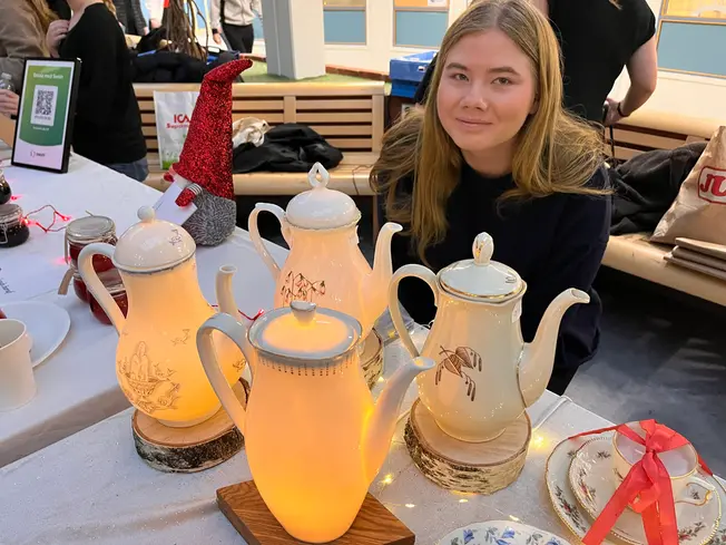 Foto på tjej framför kannor som lyser.