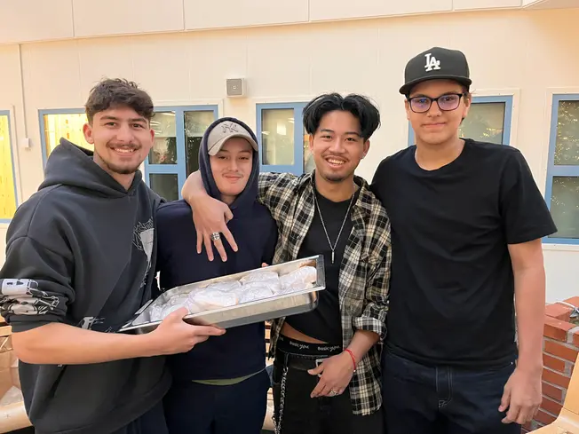 Foto på fyra killar som håller i en plåt med wraps.