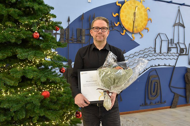 Mikael Ihreborn poserar med blommor och diplom.