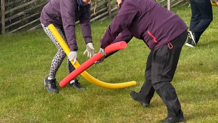 Foto på två personer som fajtas med skummgummibatonger.