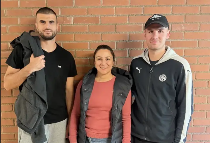 Foto på tre personer mot en tegelvägg, en man, en kvinna och en man.