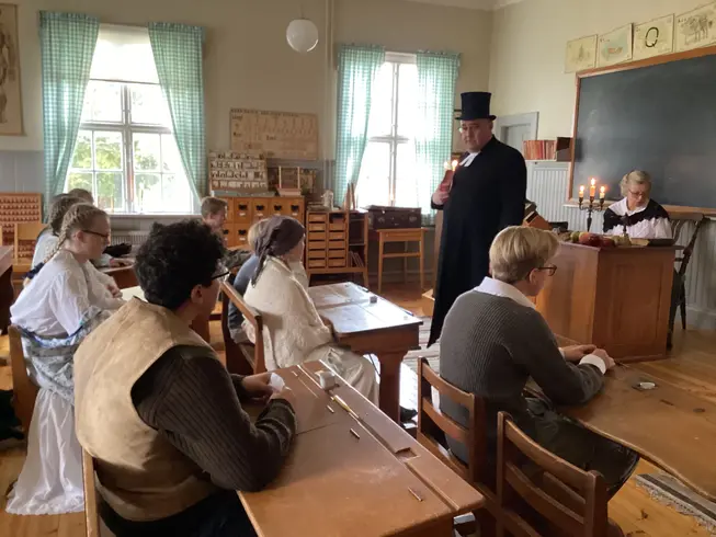 Foto på klassen med prosten som håller förhör.