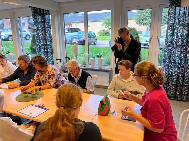 Foto på en journaslit som fotar eleverna och de äldre.