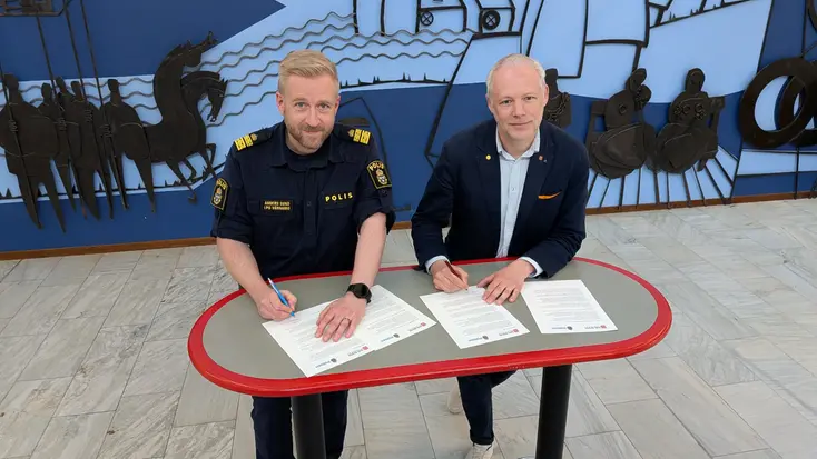 Anders Sund från Polisen och Anton Sjödell från Gislaveds kommun signerar varsin kopia av medborgarlöftet för 2025.