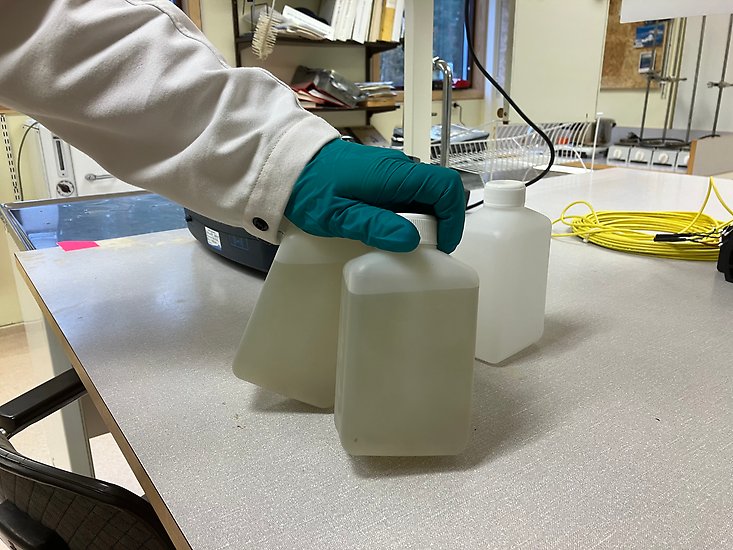 Hand som håller i två vattenprover. 