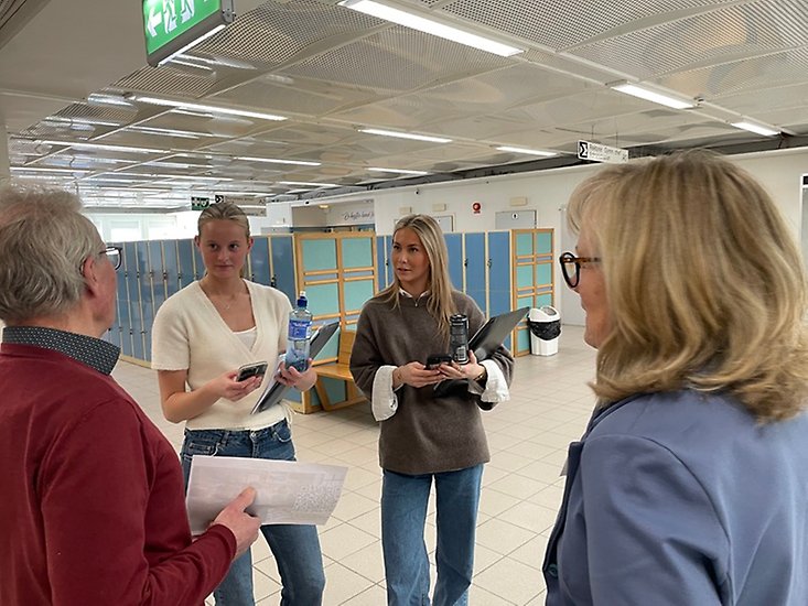 Två unga tjejer och två politiker samtalar