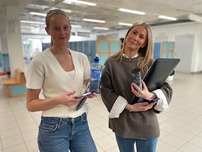 Två tjejer framför skåpen i gymnasiegången