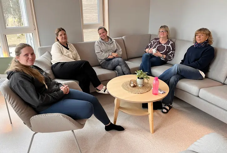 Personal som sitter i en soffa och fikar.