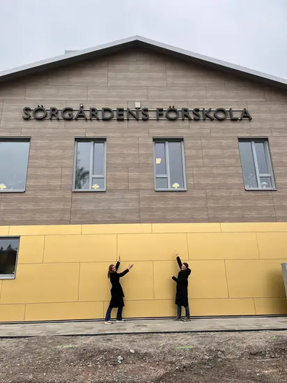 Foto på rektor och specialpedagog framför den nybyggda förskolan.