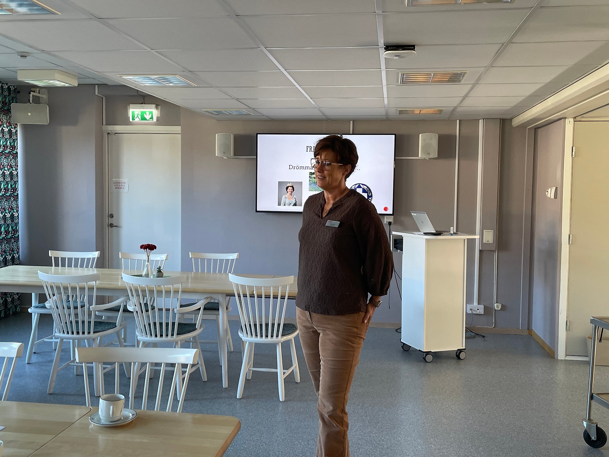 En kvinna som står framför en stor skärm.