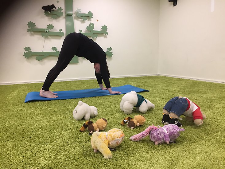 kvinna i yogaövning med nallar som gör samma övning.