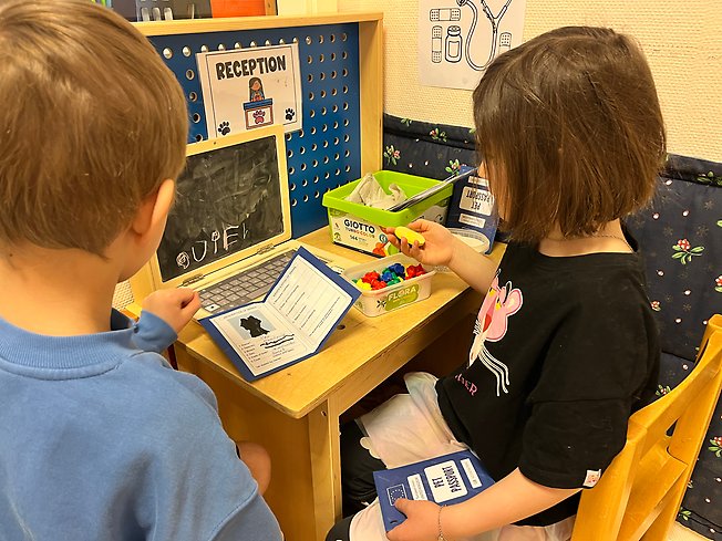 Foto på två barn som leker veterinär.