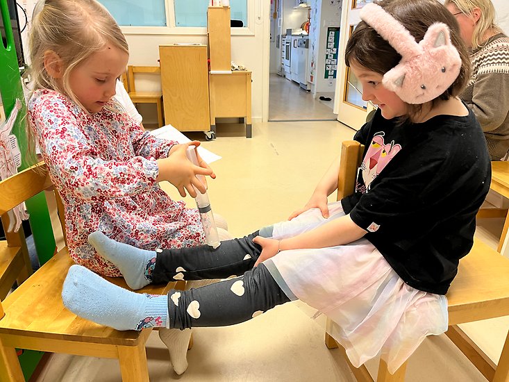 Foto på två flickor som leker doktor och patient.